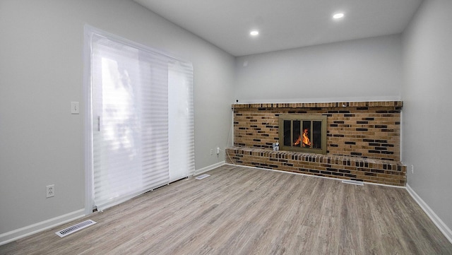 1796 Norfolk Ave, Ypsilanti, MI 48198 - unfurnished living room featuring wood finished floors, a brick fireplace, and recessed lighting