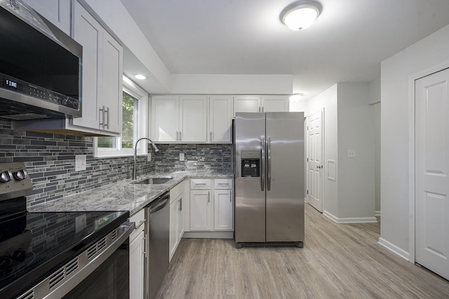 1796 Norfolk Ave, Ypsilanti, MI 48198 - kitchen featuring stainless steel appliances, light wood finished floors, light stone countertops, tasteful backsplash, and white cabinetry