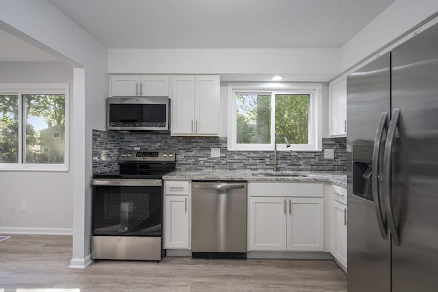 1796 Norfolk Ave, Ypsilanti, MI 48198 - kitchen featuring stainless steel appliances, light stone counters, white cabinets, and tasteful backsplash