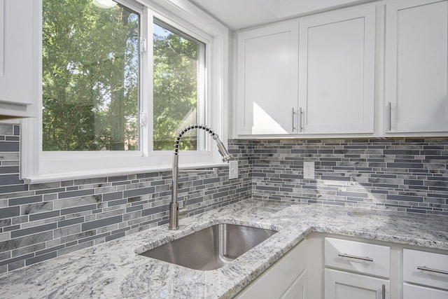 1796 Norfolk Ave, Ypsilanti, MI 48198 - kitchen featuring white cabinets, tasteful backsplash, and light stone countertops