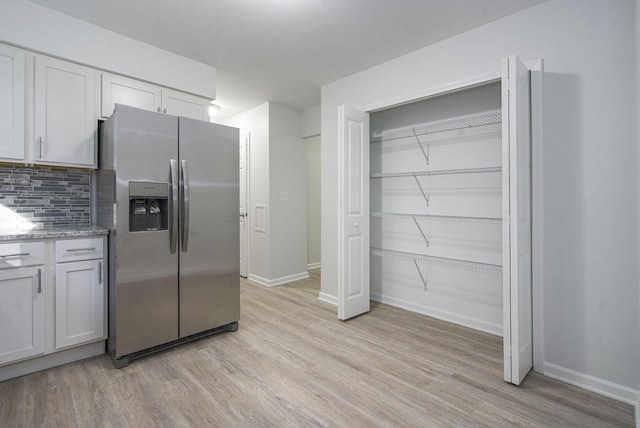 1796 Norfolk Ave, Ypsilanti, MI 48198 - kitchen featuring stainless steel fridge with ice dispenser, light wood-type flooring, tasteful backsplash, and light stone countertops