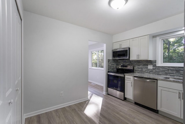 1796 Norfolk Ave, Ypsilanti, MI 48198 - kitchen with stainless steel appliances, light wood finished floors, backsplash, stone countertops, and white cabinets