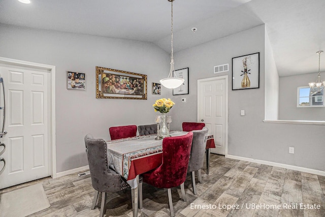 4061 Tributary Dr, Holland, MI 49424 - dining room with lofted ceiling, wood finished floors, and a chandelier