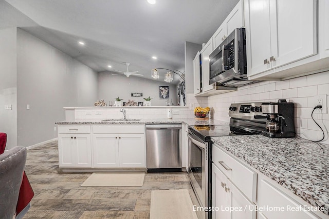 4061 Tributary Dr, Holland, MI 49424 - kitchen with stainless steel appliances, a peninsula, decorative backsplash, white cabinetry, and recessed lighting