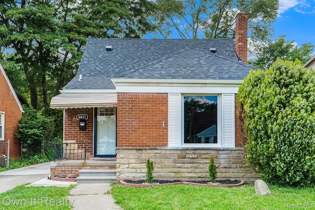 6031 Grandville Ave, Dearborn, MI 48228 - view of front facade with a shingled roof, brick siding, and a chimney