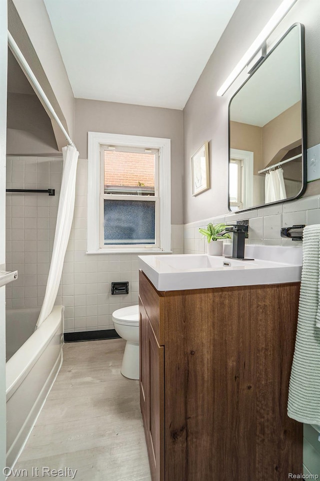 6031 Grandville Ave, Dearborn, MI 48228 - full bathroom with tile walls, vanity, plenty of natural light, wood finished floors, and shower / bath combo
