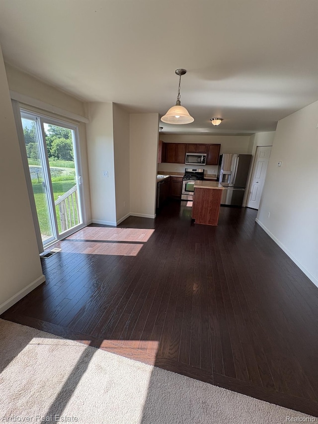 8213 Bayberry Ct, Dexter, MI 48130 - kitchen with stainless steel appliances, light countertops, open floor plan, dark wood-style flooring, and pendant lighting