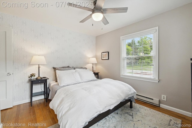 2351 Earlmont Rd, Berkley, MI 48072 - bedroom with a baseboard radiator, wallpapered walls, an accent wall, wood finished floors, and a ceiling fan