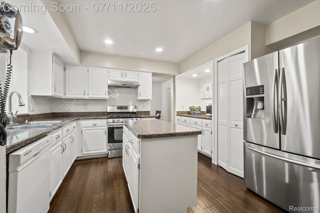 2686 Orbit Dr, Lake Orion, MI 48360 - kitchen with appliances with stainless steel finishes, a center island, under cabinet range hood, dark wood-style floors, and recessed lighting