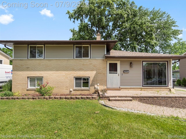 2553 Koper Dr, Macomb, MI 48310 - split level home with brick siding, a front lawn, and a chimney