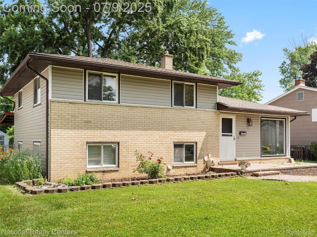 2553 Koper Dr, Macomb, MI 48310 - tri-level home featuring brick siding, a chimney, and a front yard