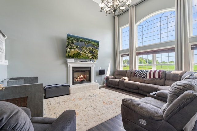 10501 Somerset Rd, Cement City, MI 49233 - living room featuring a towering ceiling, a glass covered fireplace, a chandelier, and dark wood-type flooring