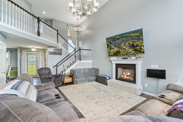 10501 Somerset Rd, Cement City, MI 49233 - living area with wood finished floors, a chandelier, stairway, a towering ceiling, and a glass covered fireplace