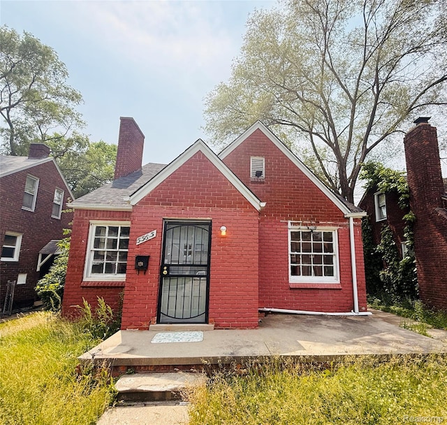 5565 Oldtown St, Detroit, MI 48224 - bungalow-style house with a chimney, brick siding, and a patio