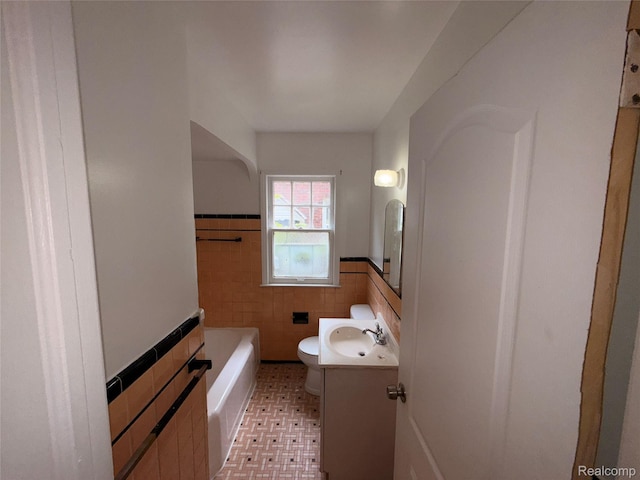 5565 Oldtown St, Detroit, MI 48224 - full bath with tile walls, vanity, a wainscoted wall, and a tub to relax in