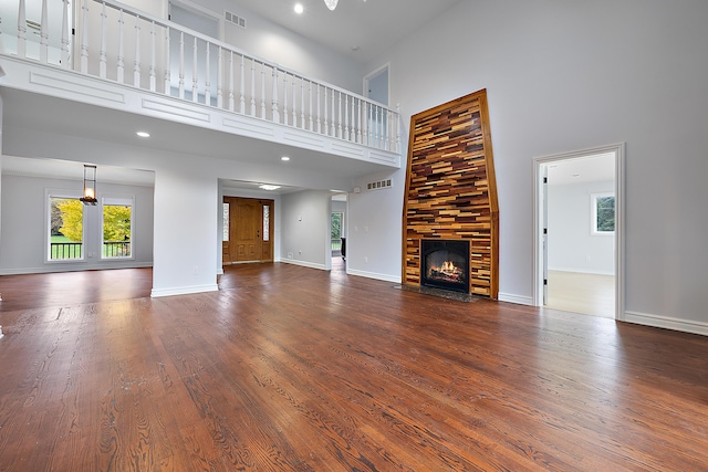 4700 Raap Rd, Bruce, MI 48065 - unfurnished living room with a towering ceiling, dark wood-style floors, a fireplace with flush hearth, and recessed lighting