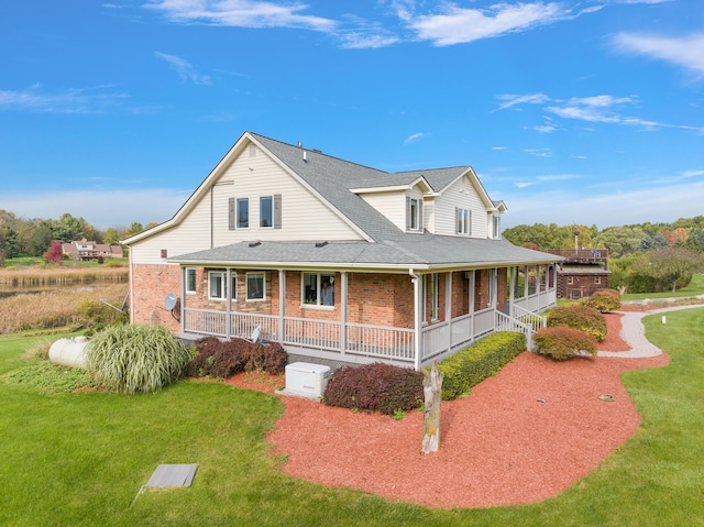 4700 Raap Rd, Bruce, MI 48065 - view of side of property featuring covered porch, brick siding, a shingled roof, and a lawn