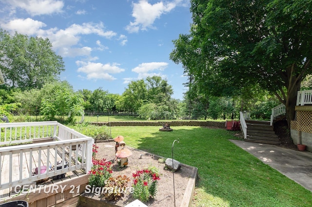 7320 N River Rd, Freeland, MI 48623 - fenced backyard featuring a deck, stairway, and view of wooded area