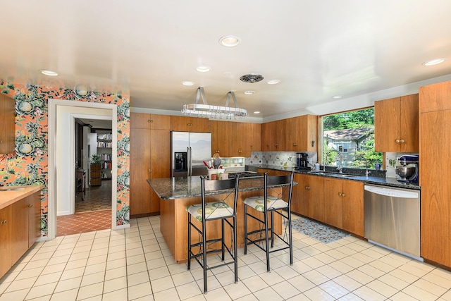 1818 Greenbriar Dr, Portage, MI 49024 - kitchen featuring stainless steel appliances, brown cabinetry, a breakfast bar area, recessed lighting, and a center island