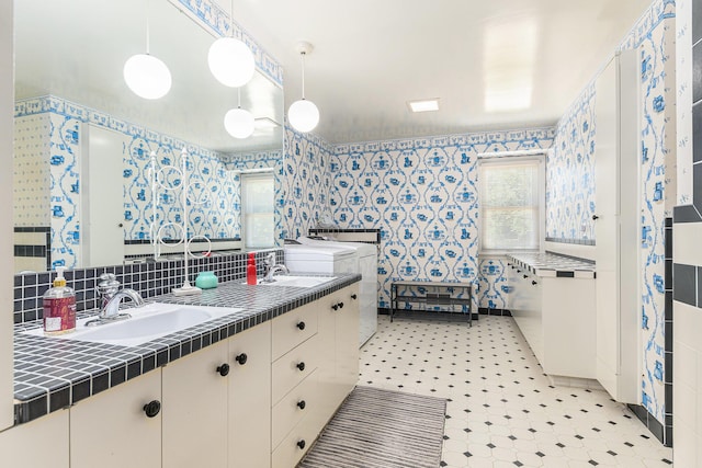 1818 Greenbriar Dr, Portage, MI 49024 - bathroom featuring wallpapered walls, double vanity, tile patterned floors, and tasteful backsplash