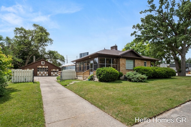 2250 Plainfield Ave NE, Grand Rapids, MI 49505 - view of front of home featuring a detached garage, a sunroom, brick siding, an outbuilding, and a chimney