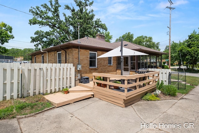 2250 Plainfield Ave NE, Grand Rapids, MI 49505 - rear view of house featuring a deck, brick siding, and a chimney