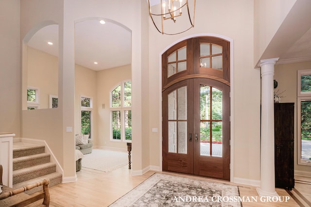 41 Bay Meadows Dr, Holland, MI 49424 - foyer entrance with french doors, arched walkways, light wood finished floors, a high ceiling, and a chandelier