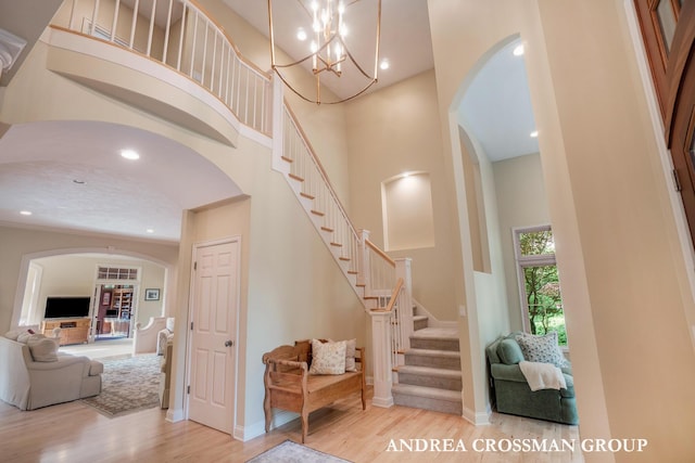 41 Bay Meadows Dr, Holland, MI 49424 - stairs featuring arched walkways, wood finished floors, a towering ceiling, recessed lighting, and a chandelier