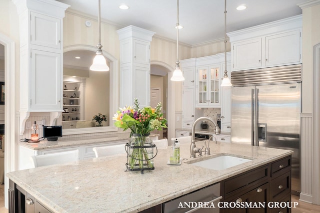 41 Bay Meadows Dr, Holland, MI 49424 - kitchen with stainless steel built in refrigerator, white cabinets, a center island with sink, hanging light fixtures, and crown molding