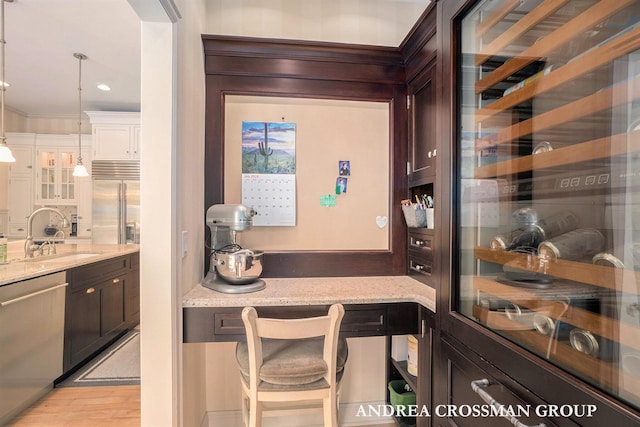 41 Bay Meadows Dr, Holland, MI 49424 - bar area with stainless steel appliances, hanging light fixtures, crown molding, light wood-type flooring, and wine cooler