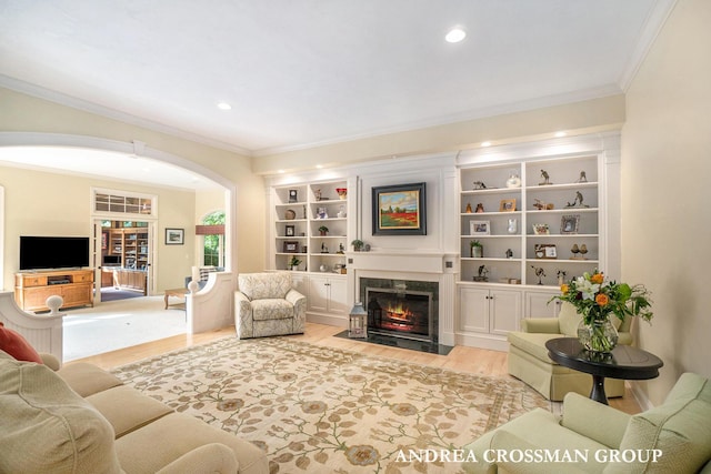 41 Bay Meadows Dr, Holland, MI 49424 - living area featuring wood finished floors, ornamental molding, a high end fireplace, arched walkways, and recessed lighting