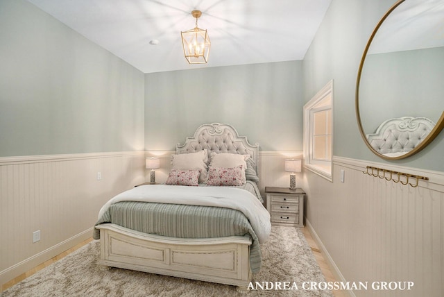 41 Bay Meadows Dr, Holland, MI 49424 - bedroom with wood finished floors, wainscoting, and a chandelier