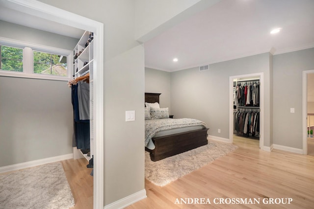 41 Bay Meadows Dr, Holland, MI 49424 - bedroom featuring light wood-type flooring, a spacious closet, ornamental molding, recessed lighting, and a closet