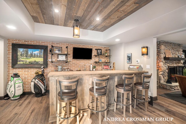 41 Bay Meadows Dr, Holland, MI 49424 - indoor wet bar featuring wood finished floors, wood ceiling, a tray ceiling, a stone fireplace, and recessed lighting
