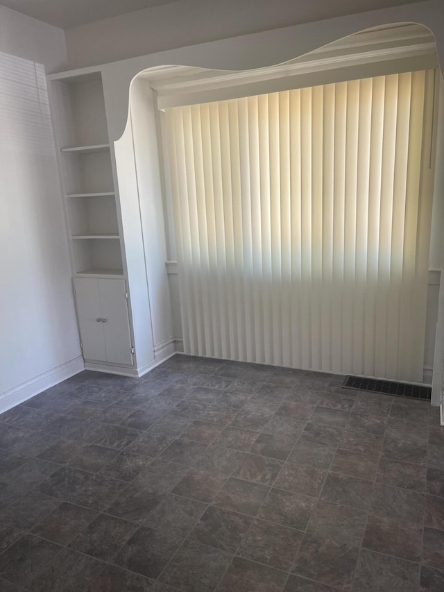 515 Hall St SE, Grand Rapids, MI 49507 - unfurnished room featuring arched walkways, built in features, and stone finish flooring