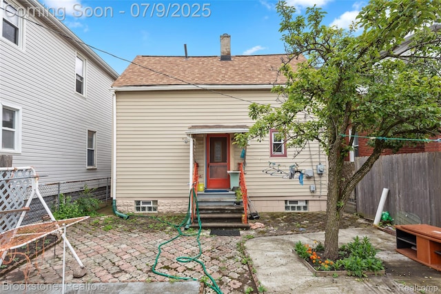3831 Casmere St, Hamtramck, MI 48212 - back of house featuring entry steps, a shingled roof, a patio area, and a chimney