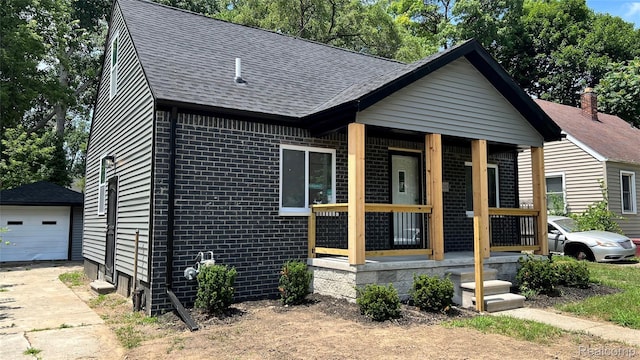 16535 Lamphere St, Detroit, MI 48219 - view of front of property with roof with shingles, brick siding, an outbuilding, a porch, and concrete driveway