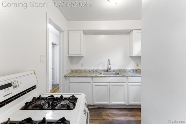 19132 Gilchrist St, Detroit, MI 48235 - kitchen with gas range oven, white cabinets, dark wood finished floors, and light stone counters