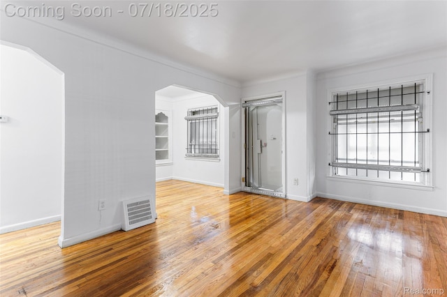 19132 Gilchrist St, Detroit, MI 48235 - empty room with arched walkways and hardwood / wood-style flooring