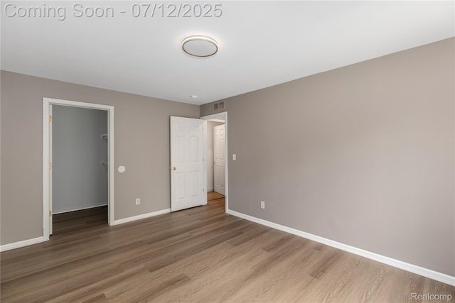 5548 Pine Aires Dr, Sterling Heights, MI 48314 - unfurnished bedroom with wood finished floors, a spacious closet, and a closet