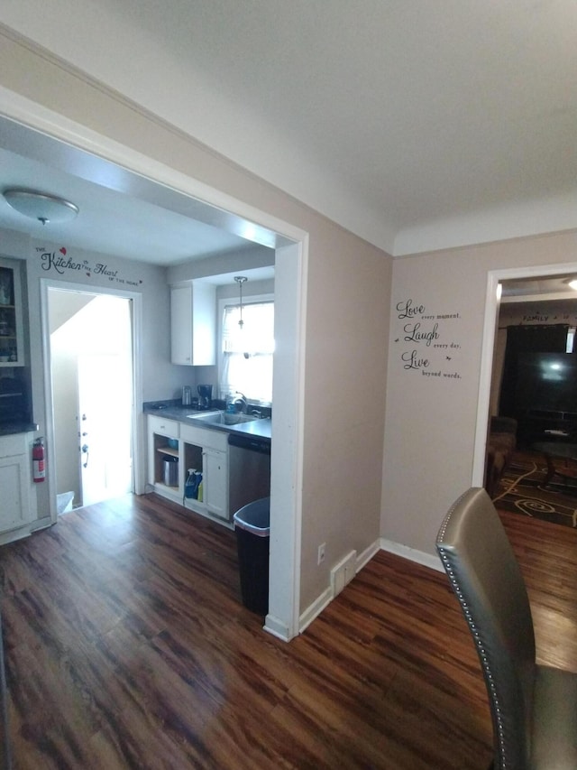 3539 14th St, Wyandotte, MI 48192 - kitchen with dark wood finished floors, stainless steel dishwasher, white cabinets, and dark countertops