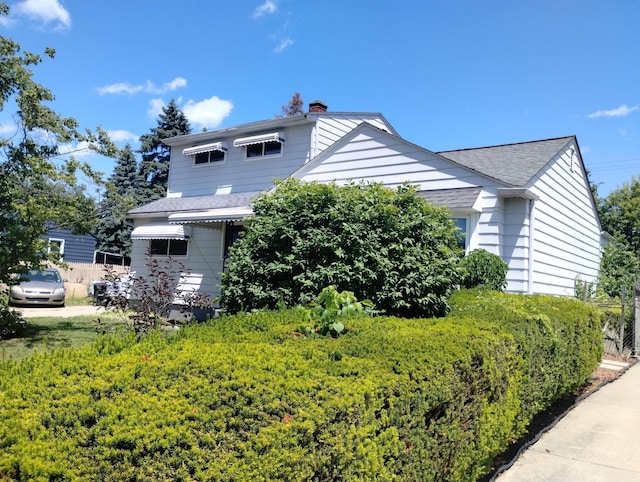 3539 14th St, Wyandotte, MI 48192 - view of property exterior featuring a chimney and a shingled roof