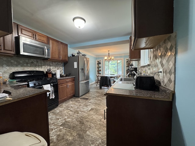 2728 Brook Dr, Kalamazoo, MI 49004 - kitchen featuring stainless steel appliances, decorative backsplash, a chandelier, light stone finish floors, and dark countertops