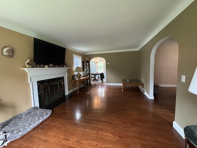 2728 Brook Dr, Kalamazoo, MI 49004 - living room featuring arched walkways, wood finished floors, a glass covered fireplace, and a chandelier