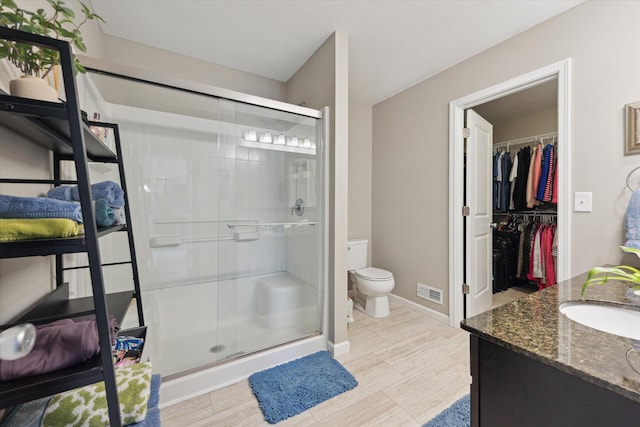 58852 Silvergrass Dr, Mattawan, MI 49071 - bathroom with a stall shower, vanity, a walk in closet, and wood finished floors