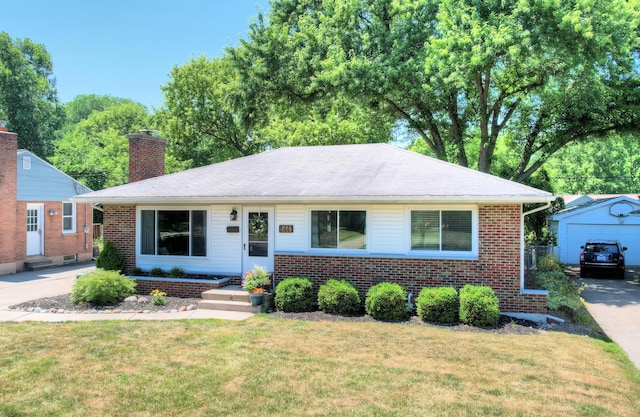 1441 Lewison Ave NE, Grand Rapids, MI 49505 - view of front of home with an outdoor structure, brick siding, a chimney, and a front lawn