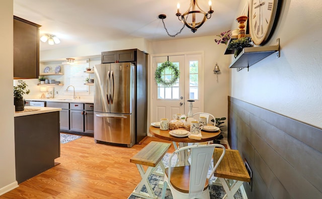 1441 Lewison Ave NE, Grand Rapids, MI 49505 - kitchen with freestanding refrigerator, open shelves, a chandelier, light countertops, and light wood-style flooring