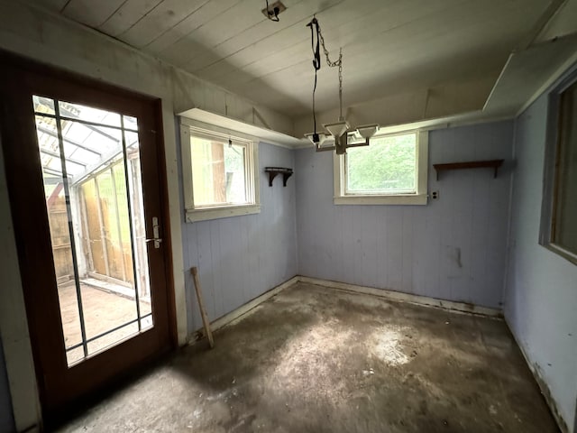 521 N 3rd St, Niles, MI 49120 - unfurnished dining area featuring unfinished concrete flooring and wooden walls