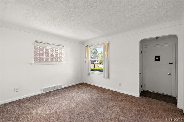 18285 Faust Ave, Detroit, MI 48219 - carpeted empty room featuring a textured ceiling and arched walkways