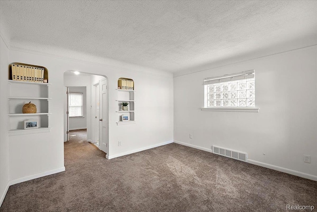 18285 Faust Ave, Detroit, MI 48219 - spare room with arched walkways, a textured ceiling, carpet, and built in features